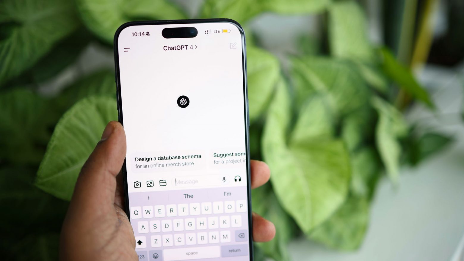 Hand hält Smartphone, auf dem ChatGPT geöffnet ist.